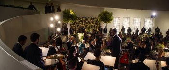 Movie still from “Annie” (2014), directed by Will Gluck – A group of people sitting at tables with musical instruments; Extreme Wide shot, High angle