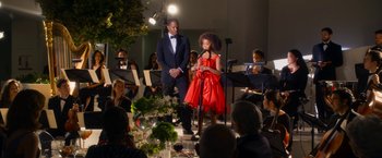 Movie still from “Annie” (2014), directed by Will Gluck – A girl in a red dress is on a stage; Wide shot, Over the shoulder angle