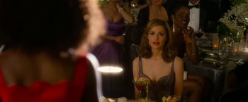 Movie still from “Annie” (2014), directed by Will Gluck – A group of women sitting at a table with drinks; Medium shot, Over the shoulder angle