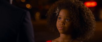 Movie still from “Annie” (2014), directed by Will Gluck – A little girl with a bow in her hair looking at the camera; Close Up shot, Over the shoulder angle