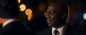 Movie still from “Annie” (2014), directed by Will Gluck – A man wearing a suit and tie looking to his left; Close Up shot, Over the shoulder angle