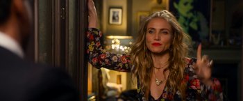 Movie still from “Annie” (2014), directed by Will Gluck – A woman leaning against a wall in a living room; Close Up shot, Over the shoulder angle