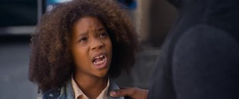 Movie still from “Annie” (2014), directed by Will Gluck – A young girl with curly black hair is being hugged by a man; Close Up shot, Over the shoulder angle