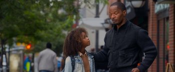 Movie still from “Annie” (2014), directed by Will Gluck – A man and a young girl standing next to each other on the street; Medium shot, Over the shoulder angle