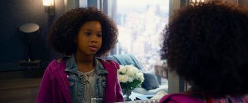 Movie still from “Annie” (2014), directed by Will Gluck – A young girl looking in the mirror in front of a window; Close Up shot, Over the shoulder angle