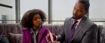 Movie still from “Annie” (2014), directed by Will Gluck – A man and a girl are playing with a pink toy; Close Up shot, Over the shoulder angle