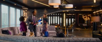 Movie still from “Annie” (2014), directed by Will Gluck – A man and a woman walking in a living room; Wide shot, Over the shoulder angle