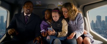 Movie still from “Annie” (2014), directed by Will Gluck – A group of people sitting on top of an airplane; Medium shot, Overhead angle