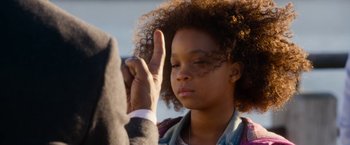 Movie still from “Annie” (2014), directed by Will Gluck – A young girl holding up a peace sign with her hand; Close Up shot, Over the shoulder angle