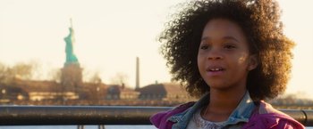 Movie still from “Annie” (2014), directed by Will Gluck – A young girl is smiling for the camera; Close Up shot, Over the shoulder angle
