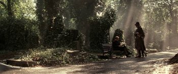 A person sitting on a bench in the middle of a forest