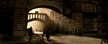 People are walking down the street under an archway