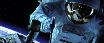 Movie still from “Armageddon” (1998), directed by Michael Bay – A person in a spacesuit is holding an antenna; Medium shot, Overhead angle