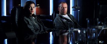 Movie still from “Armageddon” (1998), directed by Michael Bay – A man and a woman sitting at a conference table; Medium shot, Over the shoulder angle