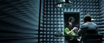 Movie still from “Armageddon” (1998), directed by Michael Bay – A man sitting at a table in front of a mirror; Wide shot, Overhead angle