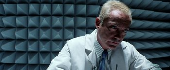 Movie still from “Armageddon” (1998), directed by Michael Bay – A man with blonde hair and a white suit; Close Up shot, Low angle