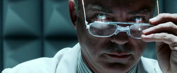 Movie still from “Armageddon” (1998), directed by Michael Bay – A person wearing glasses and a white coat; Extreme Close Up shot, Low angle