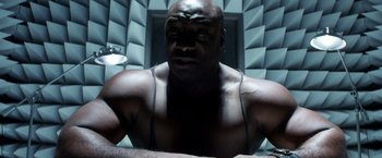 Movie still from “Armageddon” (1998), directed by Michael Bay – A man with a muscular body in a room with walls; Close Up shot, High angle