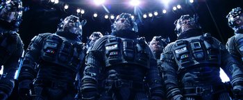 Movie still from “Armageddon” (1998), directed by Michael Bay – A group of people in space suits on a stage; Medium shot, Low angle