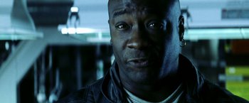 Movie still from “Armageddon” (1998), directed by Michael Bay – A man's face in a dark room; Close Up shot, Low angle