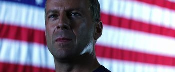 Movie still from “Armageddon” (1998), directed by Michael Bay – A man's face in front of an american flag; Close Up shot, Low angle