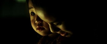 Movie still from “Armageddon” (1998), directed by Michael Bay – A young child looking at the camera with dark lighting; Extreme Close Up shot, High angle