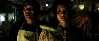 Movie still from “Armageddon” (1998), directed by Michael Bay – Two people in aprons looking at the camera; Close Up shot, Low angle