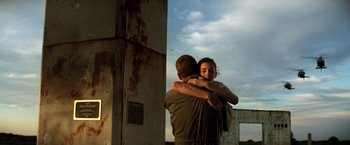 Movie still from “Armageddon” (1998), directed by Michael Bay – A man and a woman hug in front of a building; Medium shot, Low angle