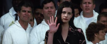 Movie still from “Armageddon” (1998), directed by Michael Bay – A woman with her hand up in the air in front of a group of people; Close Up shot, Over the shoulder angle