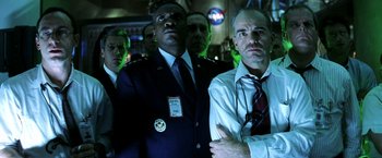 Movie still from “Armageddon” (1998), directed by Michael Bay – A group of men standing next to each other in a room; Medium shot, Low angle