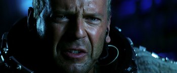 Movie still from “Armageddon” (1998), directed by Michael Bay – A man's face with ear buds; Close Up shot, Low angle