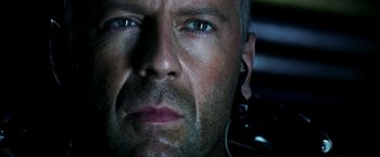 Movie still from “Armageddon” (1998), directed by Michael Bay – A man's face with ear buds in his ears; Close Up shot, Overhead angle