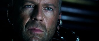 Movie still from “Armageddon” (1998), directed by Michael Bay – A man's face with ear plugs in his ears; Close Up shot, Over the shoulder angle