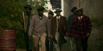 Movie still from “Fargo” (2014), created by Noah Hawley – A group of men walking down a street wearing hats; Wide shot, High angle