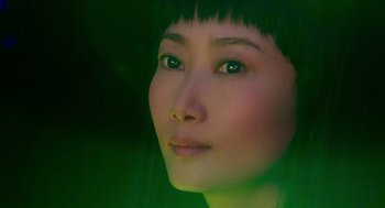 A woman's face with green light in the background
