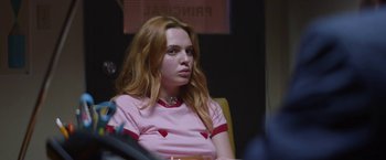 Movie still from “Assassination Nation” (2018), directed by Sam Levinson – A woman sitting in a chair with a cup in her hand; Close Up shot, Over the shoulder angle