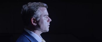 Movie still from “Assassination Nation” (2018), directed by Sam Levinson – A person wearing a suit and tie; Close Up shot, Low angle