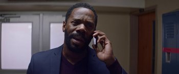 Movie still from “Assassination Nation” (2018), directed by Sam Levinson – A black man talking on a cell phone while wearing a suit; Close Up shot, Low angle