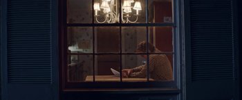 Movie still from “Assassination Nation” (2018), directed by Sam Levinson – A man sitting at a table in front of a window; Wide shot, Over the shoulder angle