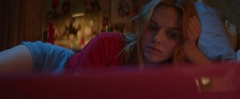 Movie still from “Assassination Nation” (2018), directed by Sam Levinson – A woman sitting on a couch looking at the camera; Close Up shot, Low angle