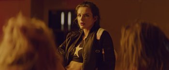 Movie still from “Assassination Nation” (2018), directed by Sam Levinson – A beautiful young lady wearing a black jacket; Close Up shot, Over the shoulder angle