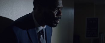 Movie still from “Assassination Nation” (2018), directed by Sam Levinson – A man wearing a suit and tie looking to his left; Close Up shot, Over the shoulder angle