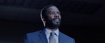 Movie still from “Assassination Nation” (2018), directed by Sam Levinson – A man in a suit and tie looking upward; Close Up shot, Low angle