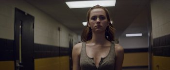 Movie still from “Assassination Nation” (2018), directed by Sam Levinson – A young woman standing in a room with her eyes wide open; Close Up shot, Low angle