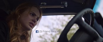 Movie still from “Assassination Nation” (2018), directed by Sam Levinson – A woman in the driver's seat of a car; Extreme Close Up shot, High angle