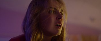Movie still from “Assassination Nation” (2018), directed by Sam Levinson – A woman with long blonde hair is looking at the camera; Close Up shot, Low angle