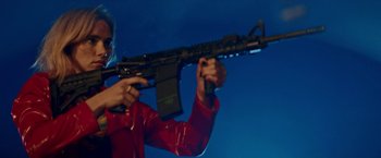 Movie still from “Assassination Nation” (2018), directed by Sam Levinson – A person holding an ar - 1 5 rifle in their hands; Medium shot, Low angle