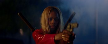 Movie still from “Assassination Nation” (2018), directed by Sam Levinson – A woman in a red jacket is holding a gun; Close Up shot, Low angle