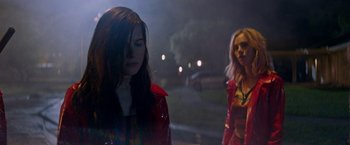 Movie still from “Assassination Nation” (2018), directed by Sam Levinson – Two women are standing in the dark near a street; Medium shot, Low angle