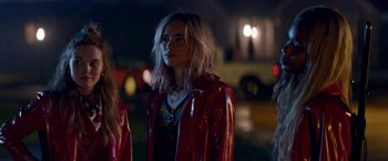 Movie still from “Assassination Nation” (2018), directed by Sam Levinson – A woman in a red jacket standing in the dark; Close Up shot, Over the shoulder angle